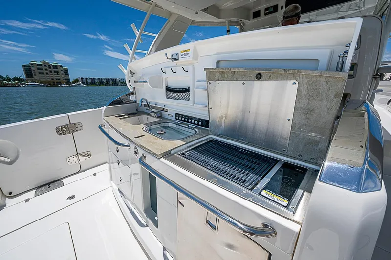 Slide: The Image of Outdoor kitchen on 2022 Boston Whaler 420 Outrage boat, featuring grill and sink. - 15