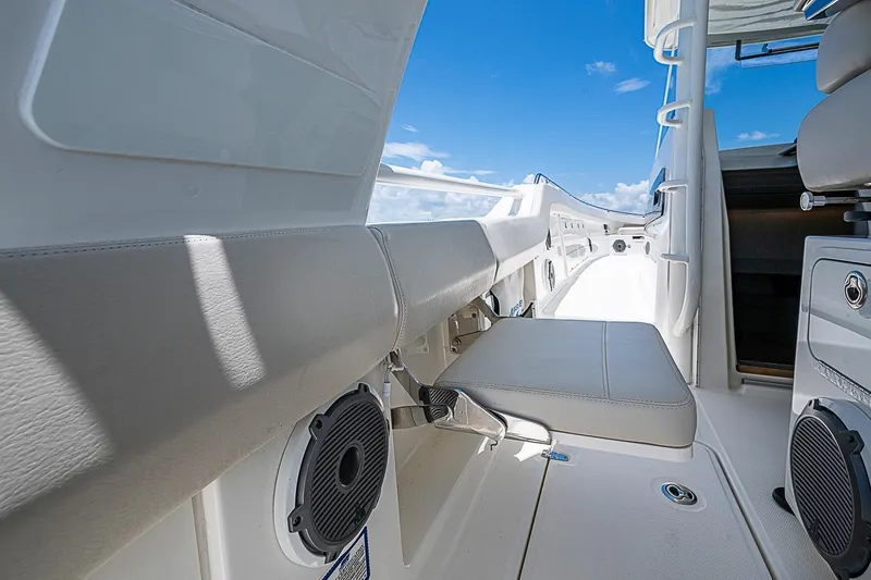 Slide: The Image of 2022 Boston Whaler 420 Outrage interior with seating and speakers under a clear blue sky. - 20