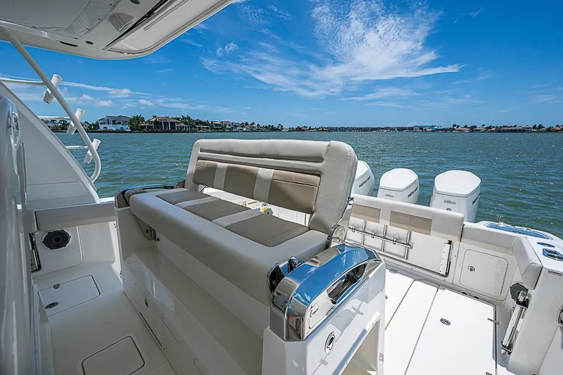 Slide: The Image of 2022 Boston Whaler 420 Outrage boat interior with seating, overlooking calm waters and blue sky. - 22