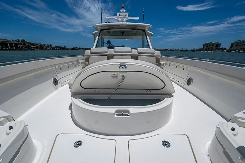 Slide: The Image of 2022 Boston Whaler 420 Outrage boat deck with seating, under a clear blue sky. - 25