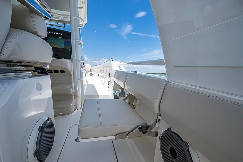 Slide: The Image of 2022 Boston Whaler 420 Outrage interior with seating and navigation equipment under clear blue sky. - 27