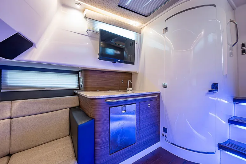 Slide: The Image of Interior of 2022 Boston Whaler 420 Outrage, featuring modern kitchenette and seating area. - 31