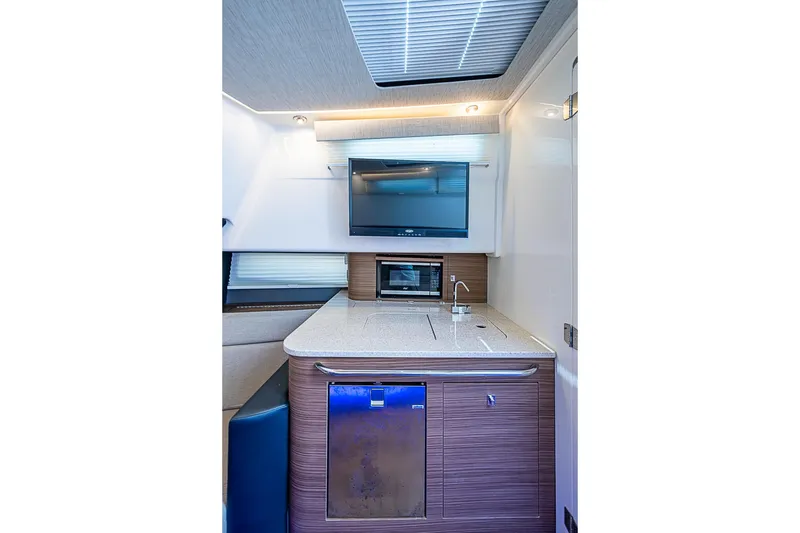 Slide: The Image of Interior of 2022 Boston Whaler 420 Outrage featuring kitchenette with TV and modern amenities. - 36