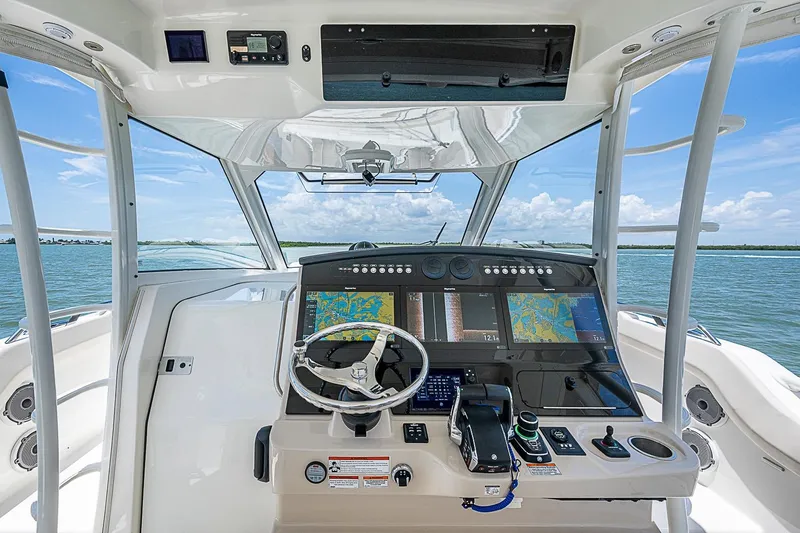 Slide: The Image of 2022 Boston Whaler 420 Outrage helm with advanced navigation systems on open water. - 4