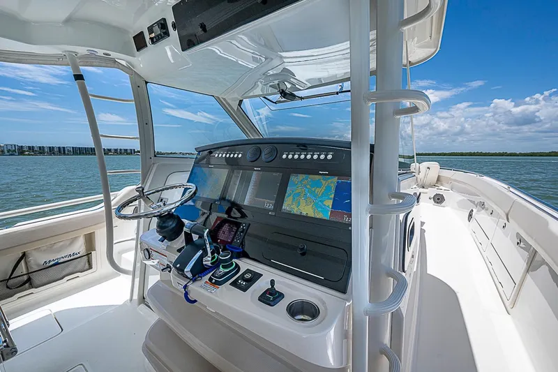 Slide: The Image of 2022 Boston Whaler 420 Outrage helm with advanced navigation system on open water. - 6