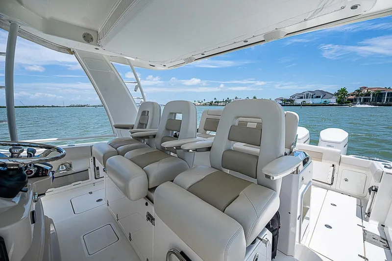 Slide: The Image of 2022 Boston Whaler 420 Outrage interior with luxurious seating and ocean view. - 9
