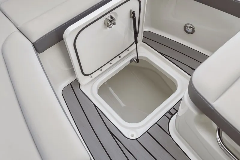 Slide: The Image of An open storage compartment on a Sea Ray SDX 270 Outboard boat, surrounded by gray and white upholstery. - 11
