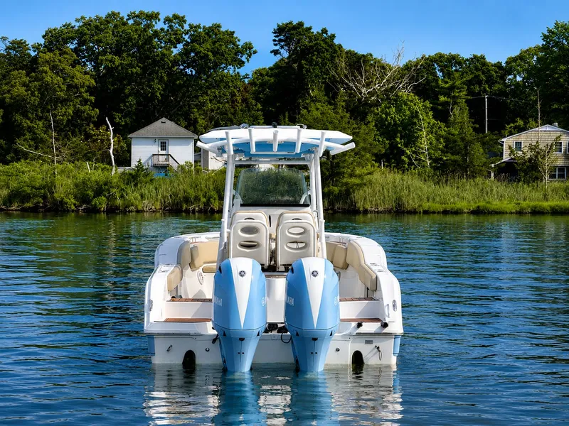 Slide: The Image of A 2018 Sea Fox 266 Commander on calm water, featuring twin outboard engines and a shaded canopy. - 4