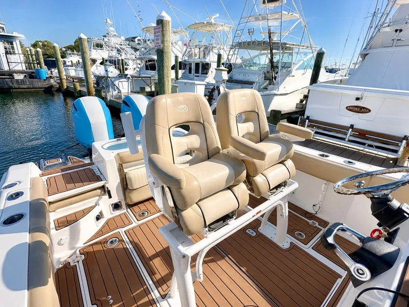 Slide: The Image of The image shows the cockpit of a 2018 Sea Fox 266 Commander with two beige seats and sleek wood decking. - 22