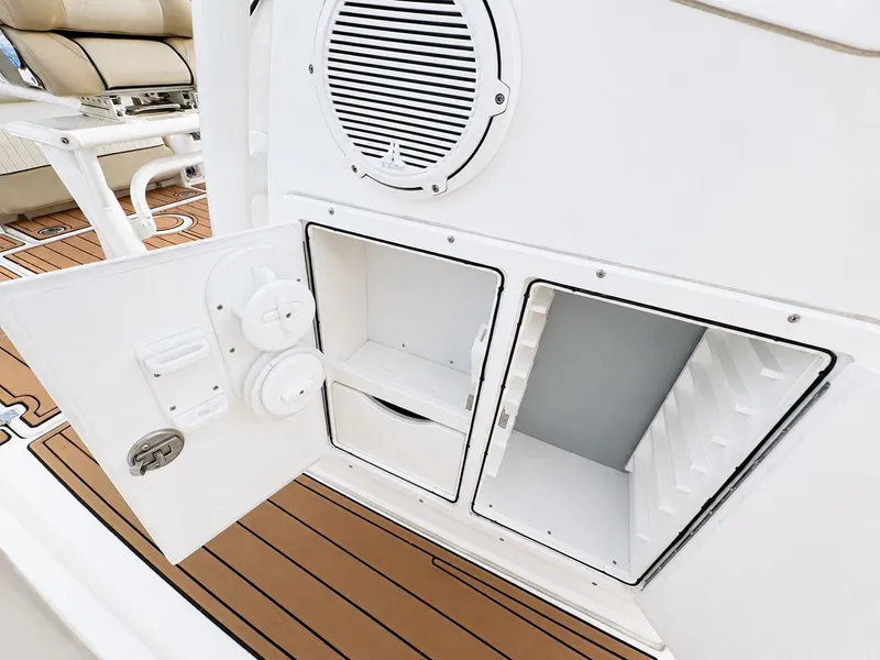 Slide: The Image of An open storage compartment on a boat with white doors and a speaker above. - 19