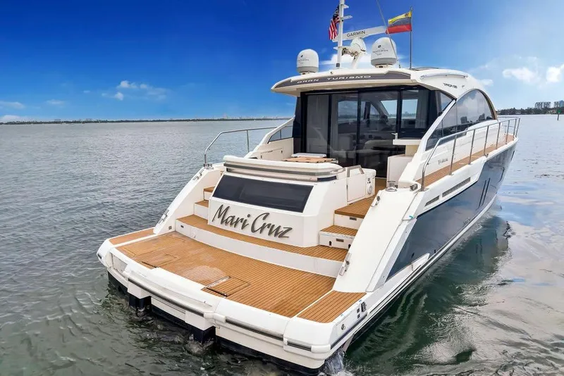 The Image of 2012 Fairline Targa 58 yacht on water, rear view with wooden deck and flags. - 0