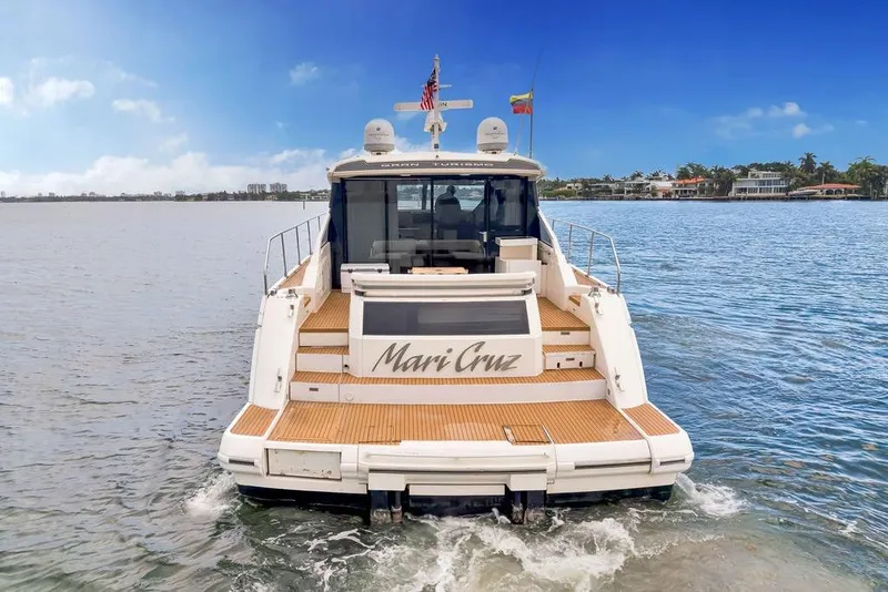 Slide: The Image of 2012 Fairline Targa 58 yacht on water, rear view, with wooden deck and flags. - 5