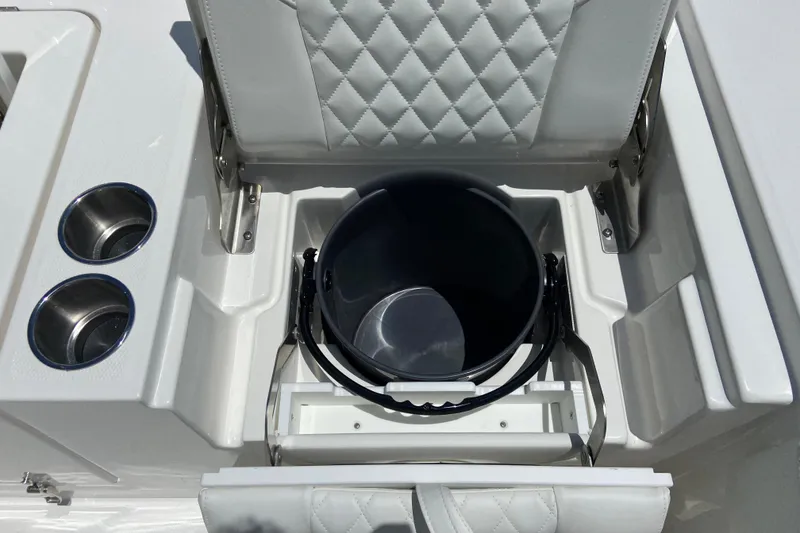 Slide: The Image of 2027 Regulator 30XO boat seat storage with integrated cup holders and bucket. - 12