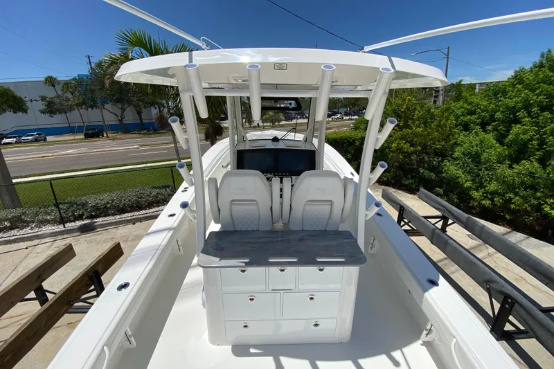 Slide: The Image of 2027 Regulator 30XO boat interior with helm station and storage, under clear blue sky. - 13