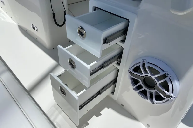 Slide: The Image of Open storage drawers and speaker on 2027 Regulator 30XO boat interior. - 21