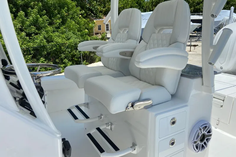 Slide: The Image of Luxurious white seating on 2027 Regulator 30XO boat, featuring armrests and footrests. - 23
