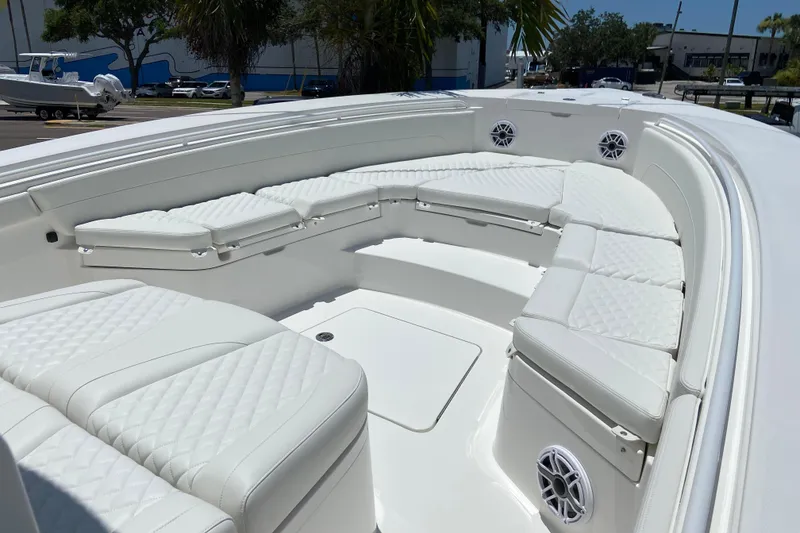 Slide: The Image of Luxurious seating on 2027 Regulator 30XO boat, featuring white quilted cushions and built-in speakers. - 45
