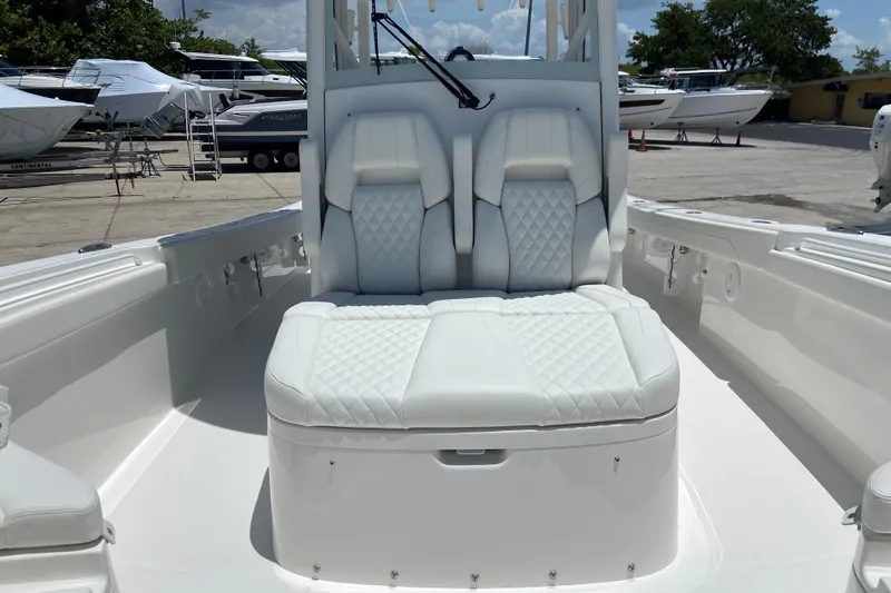 Slide: The Image of 2027 Regulator 30XO boat with luxurious white seating in a marina setting. - 47