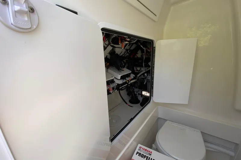 Slide: The Image of Interior view of a 2027 Regulator 30XO boat, showcasing wiring and a compact toilet. - 54