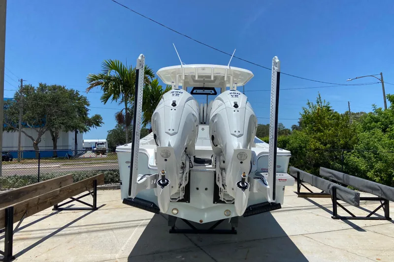 Slide: The Image of 2027 Regulator 30XO boat with dual outboard engines, parked outdoors under clear blue sky. - 57