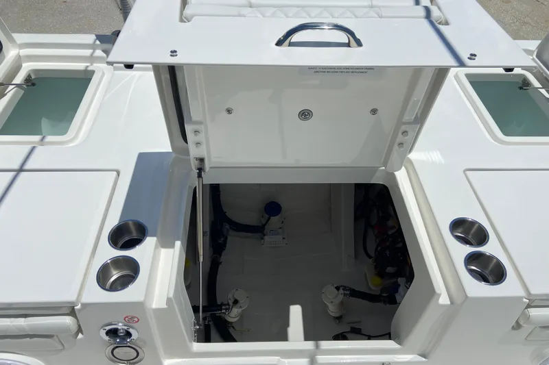 Slide: The Image of 2027 Regulator 30XO boat interior with open hatch, showcasing storage and cup holders. - 8