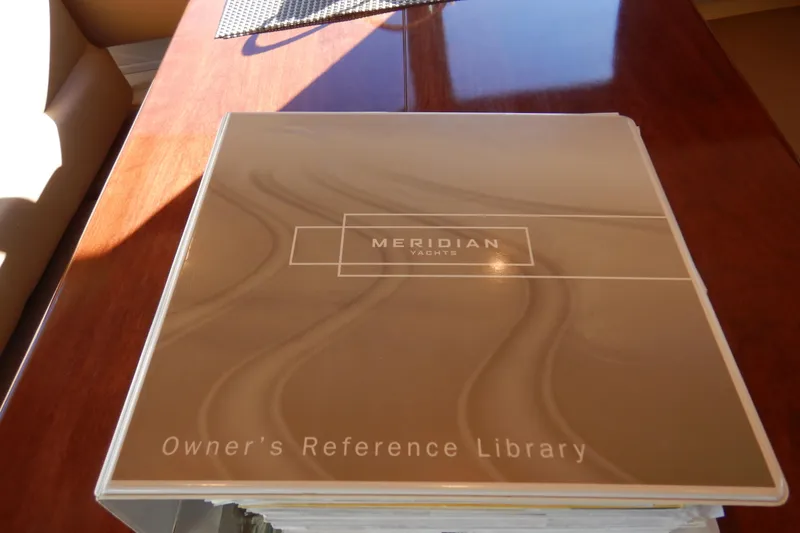 Slide: The Image of Owner's reference library for 2008 Meridian 411 Sedan yacht on wooden table. - 63