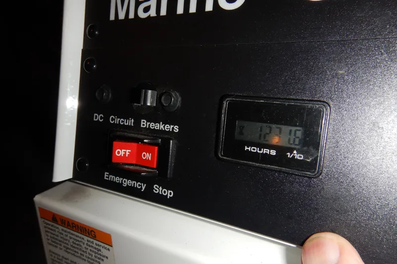 Slide: The Image of Close-up of a 2008 Meridian 411 Sedan circuit breaker panel with hour meter reading 127.6. - 56