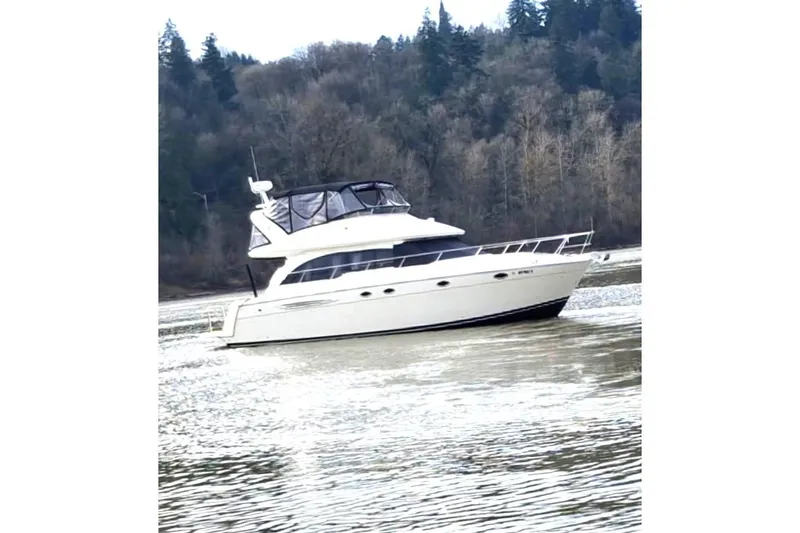 The Image of 2008 Meridian 411 Sedan yacht cruising on a scenic river with forested background. - 0