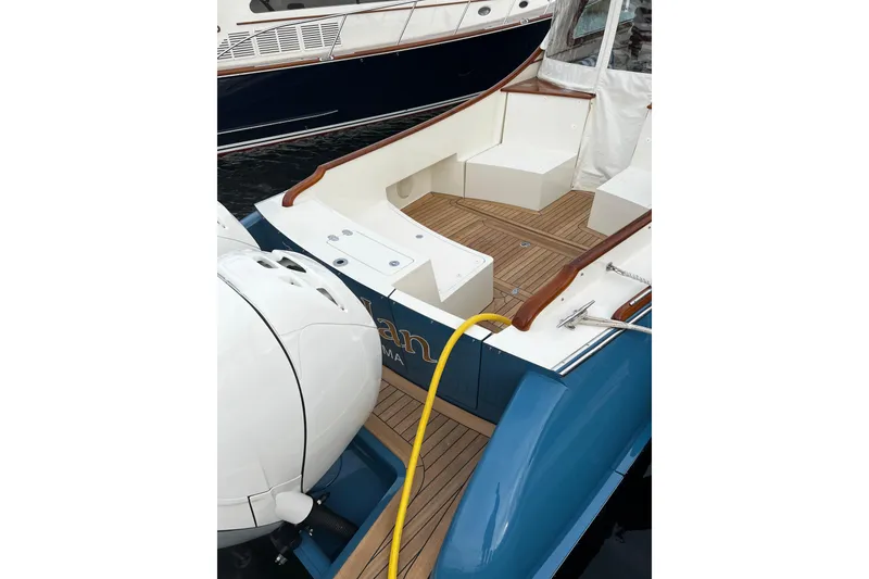 Slide: The Image of Hinckley 35 boat, 2022 model, featuring a sleek deck with wooden accents and seating. - 10
