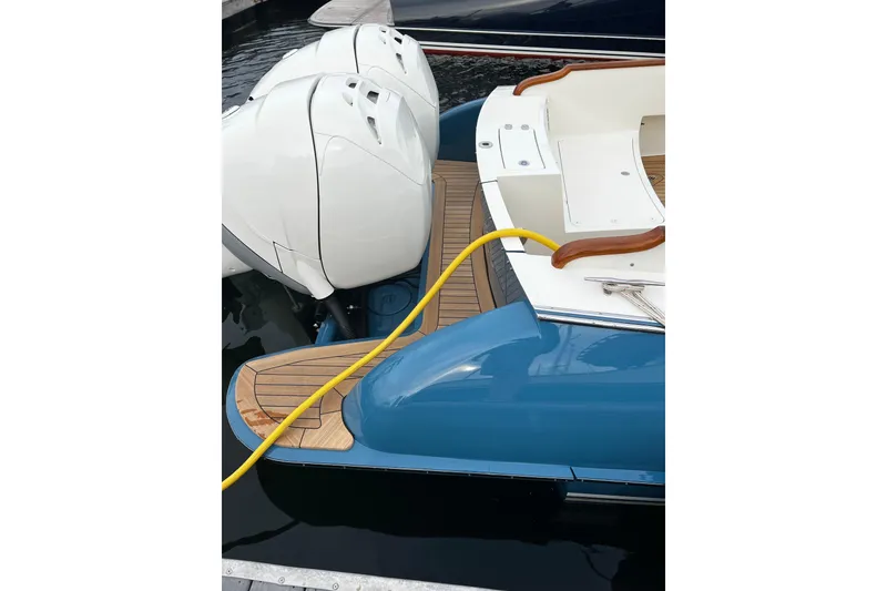 Slide: The Image of 2022 Hinckley 35 boat with dual outboard engines and teak deck, docked at marina. - 11