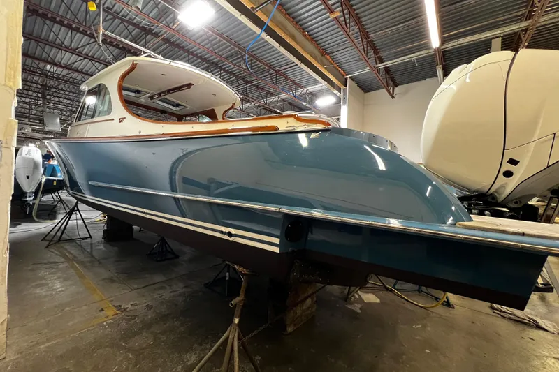 Slide: The Image of 2022 Hinckley 35 boat in a workshop, showcasing sleek blue hull design. - 13