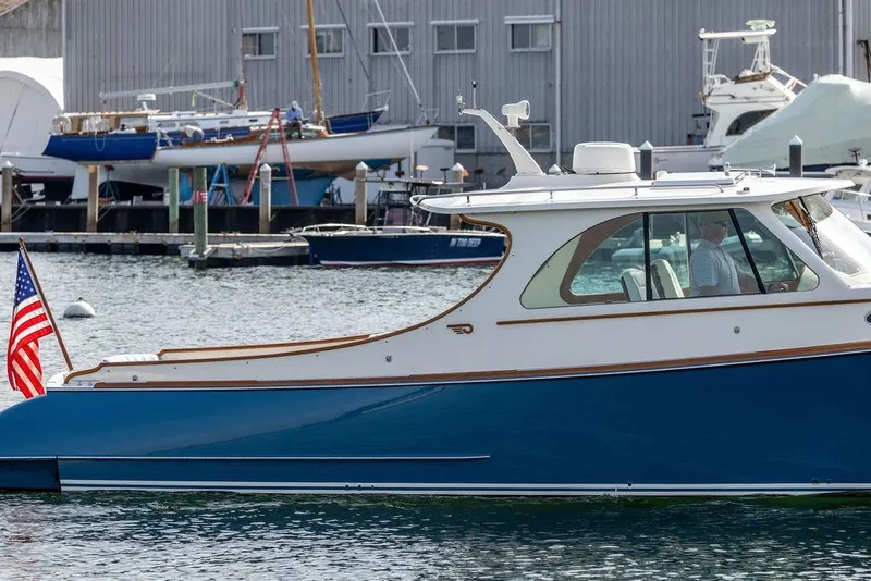 Slide: The Image of Hinckley 35 yacht, 2022 model, docked in a marina with American flag. - 6