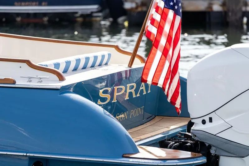 Slide: The Image of Hinckley 35 boat, 2022 model, with American flag and blue-striped seating. - 9