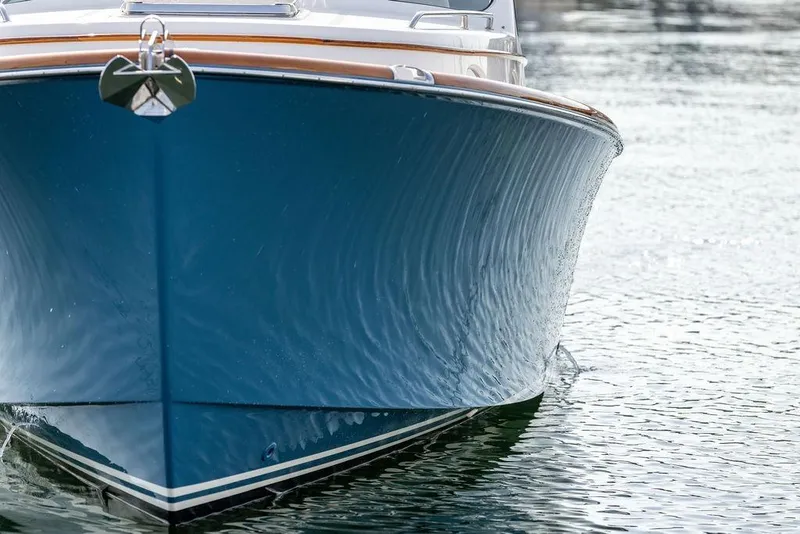 Slide: The Image of Hinckley 35 boat, 2022 model, with sleek blue hull on calm water. - 8