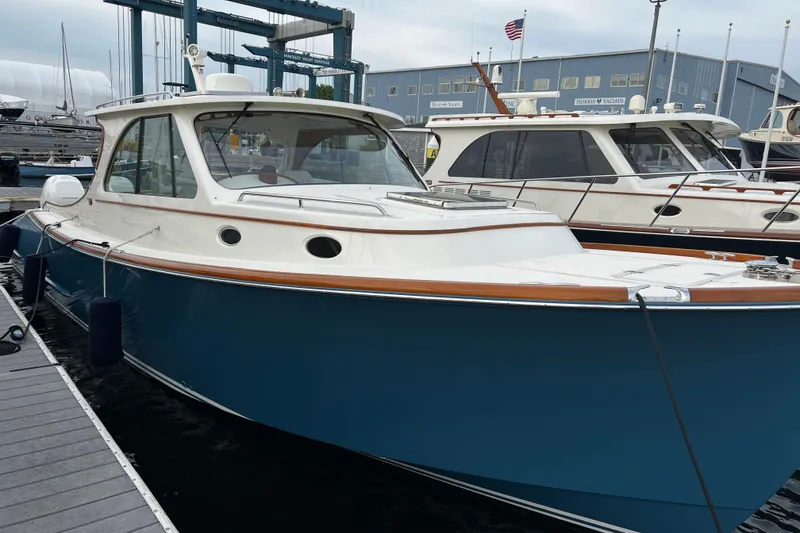 Slide: The Image of 2022 Hinckley 35 yacht docked at marina, featuring sleek blue hull and elegant design. - 2