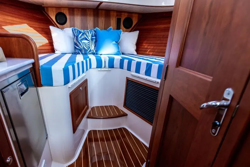Slide: The Image of Luxurious cabin interior of 2022 Hinckley 35 yacht with striped bedding and wooden accents. - 24
