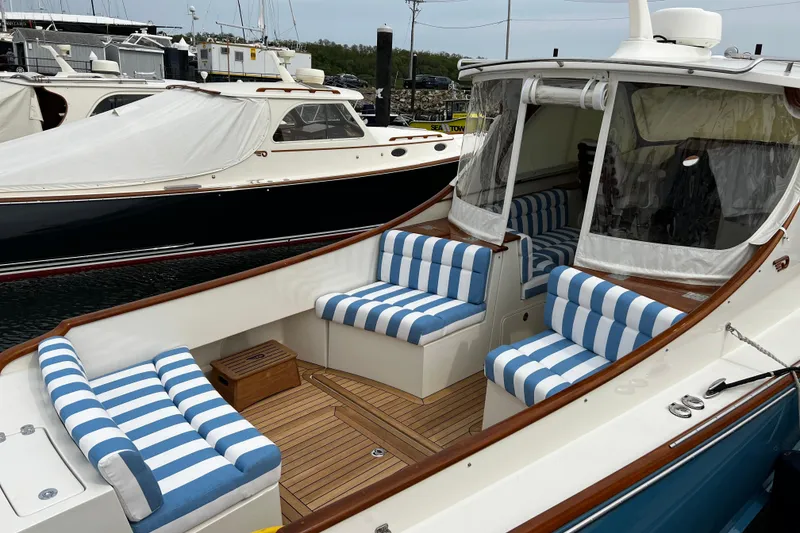 Slide: The Image of Hinckley 35 boat, 2022 model, featuring striped seating and elegant wooden deck. - 4