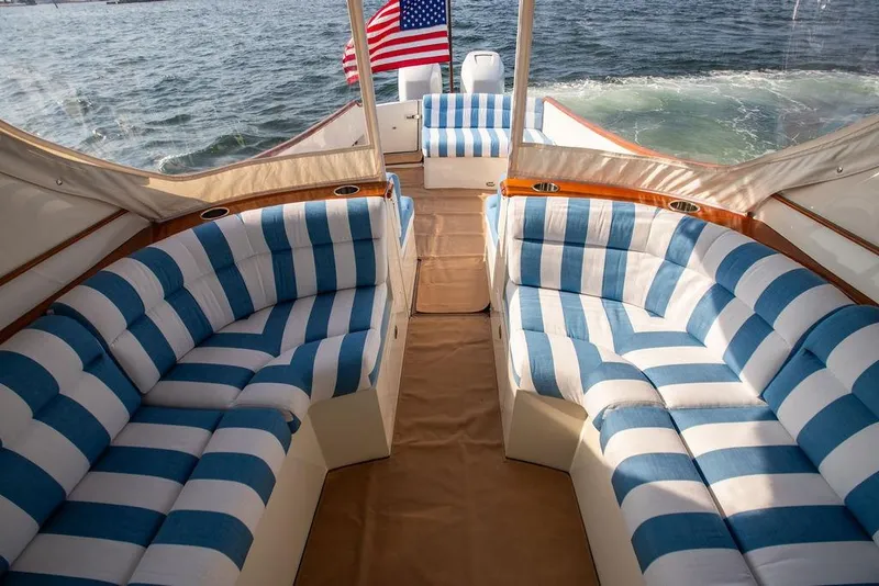 Slide: The Image of Luxurious 2022 Hinckley 35 yacht interior with striped seating and American flag. - 17