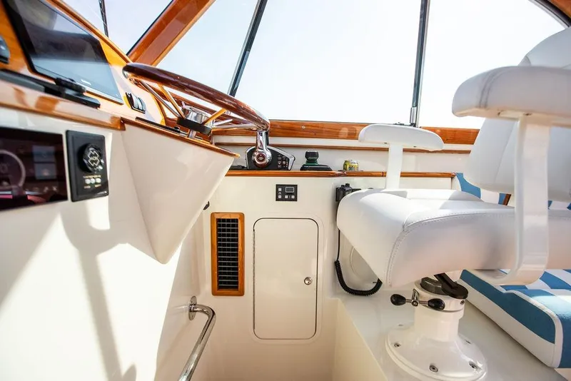 Slide: The Image of Interior of 2022 Hinckley 35 boat with white seating and wooden accents. - 13