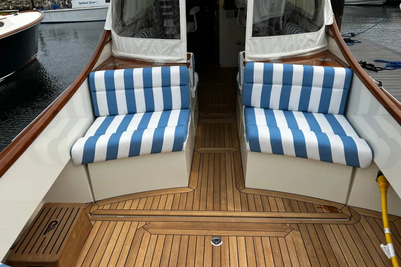 Slide: The Image of Hinckley 35 yacht interior with striped blue cushions and wooden flooring, 2022 model. - 5