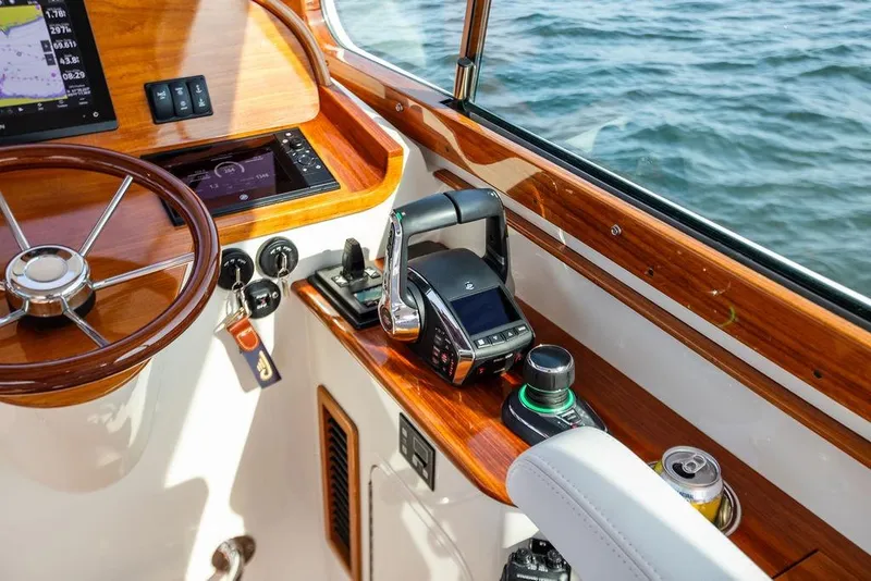 Slide: The Image of Hinckley 35 boat helm with wooden dashboard and modern controls, 2022 model. - 12