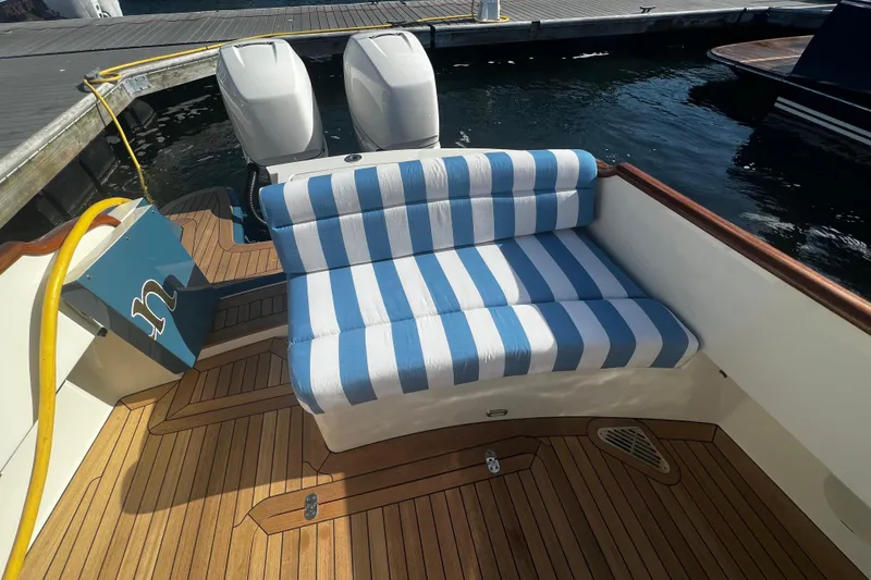 Slide: The Image of Hinckley 35 (2022) boat with striped seating and dual outboard motors at dock. - 6