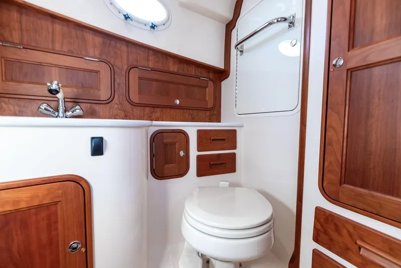 Slide: The Image of Hinckley 35 yacht bathroom interior, featuring wooden cabinetry and modern fixtures, 2022 model. - 25