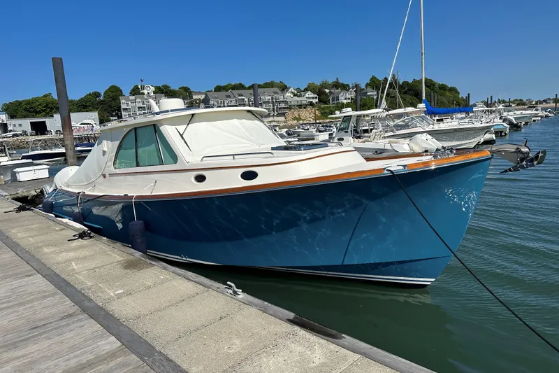 Slide: The Image of Hinckley 35 boat, 2022 model, docked at a marina under clear blue skies. - 8