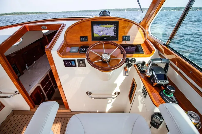 Slide: The Image of Helm of 2022 Hinckley 35 yacht with wooden accents and navigation equipment. - 11