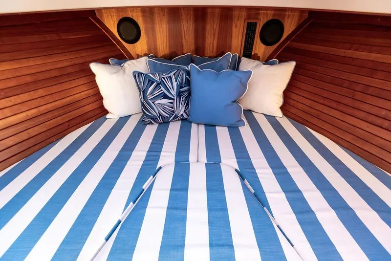 Slide: The Image of Cozy cabin interior of 2022 Hinckley 35 with striped bedding and decorative pillows. - 23