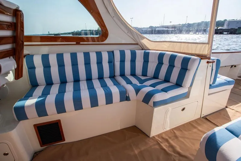Slide: The Image of Luxury seating on 2022 Hinckley 35 yacht with blue and white striped cushions. - 16