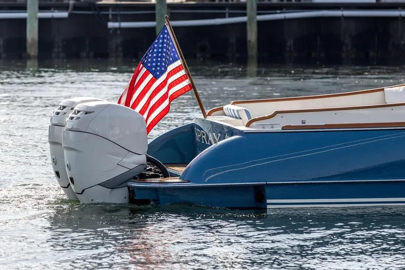 Slide: The Image of Blue 2022 Hinckley 35 boat with dual engines and American flag on water. - 7