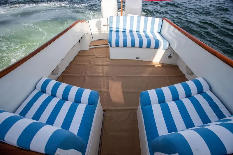 Slide: The Image of Luxury seating area on 2022 Hinckley 35 boat with striped cushions. - 19