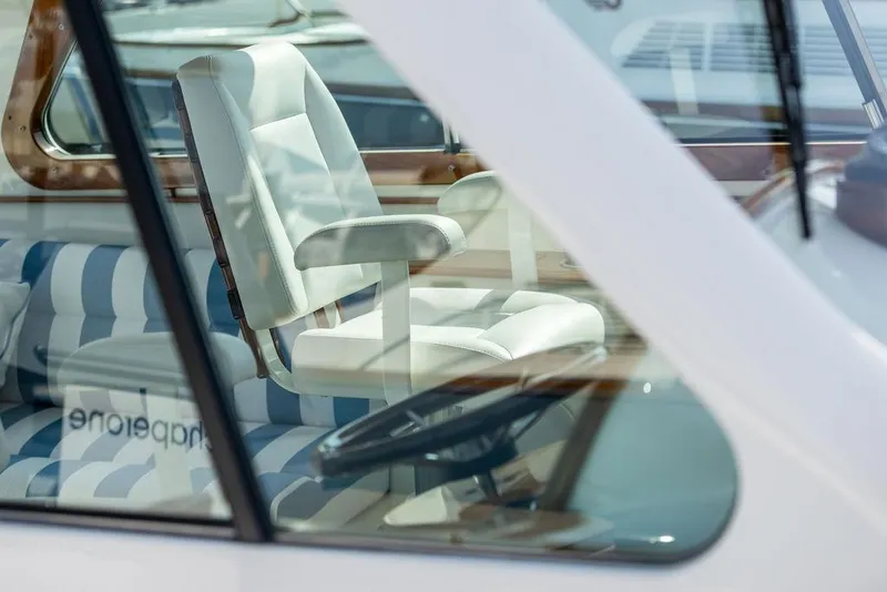 Slide: The Image of Interior view of 2022 Hinckley 35 boat, featuring a white captain's chair and striped seating. - 15